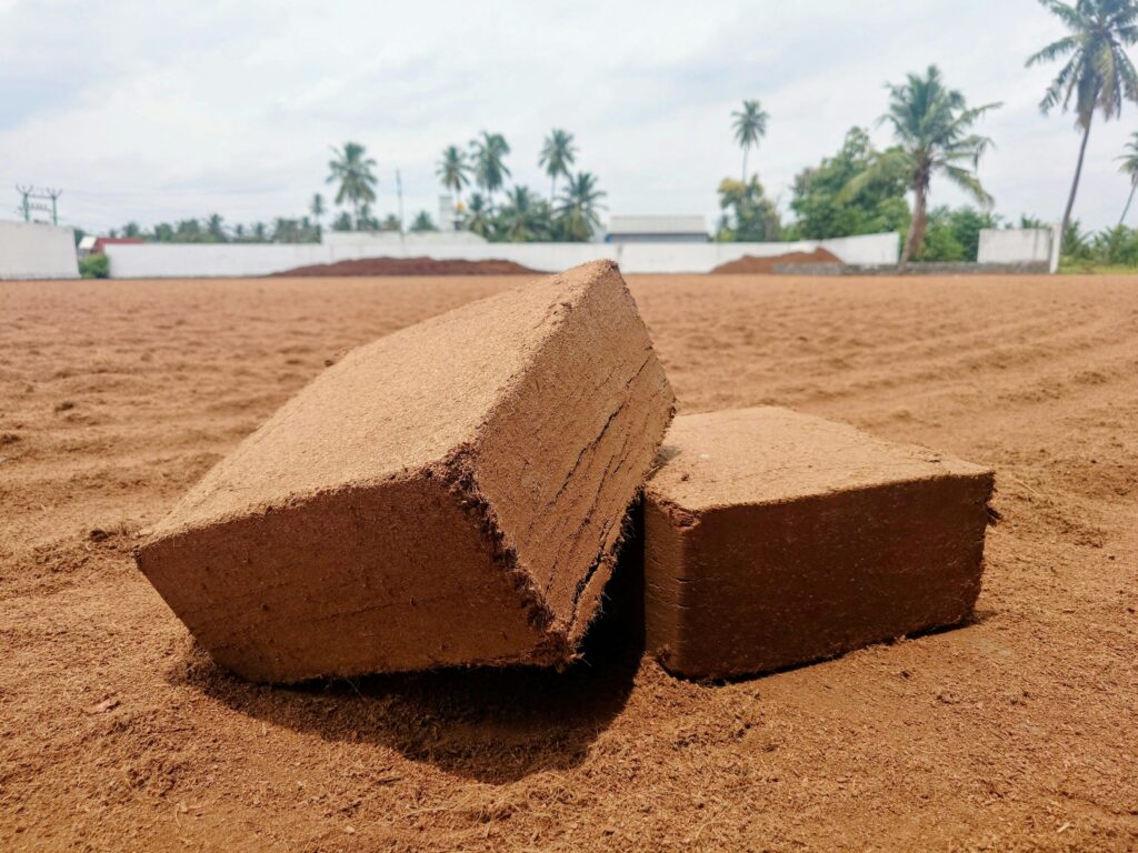 Close-up of coconut coir peat blocks on farmland in Omalur, India, used for gardening and agriculture.