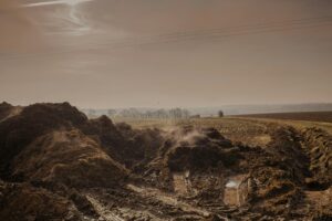 A serene rural landscape featuring vast fields under a cloudy sky, capturing nature's beauty.